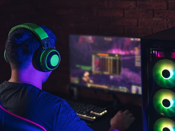 Business Multi Tenant Feature Hero 600x450 Man with headphones sitting in dark with computer lit up