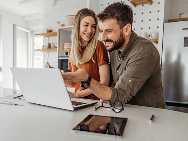 Couple Kitchen Table Features 600x450 Couple looking at laptop in kitchen