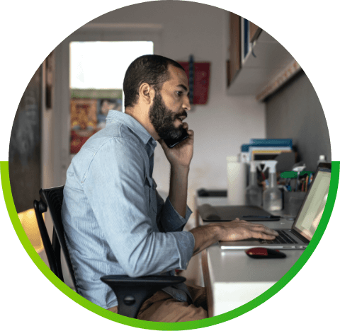 man talking on phone at home office while using VoIP phone service